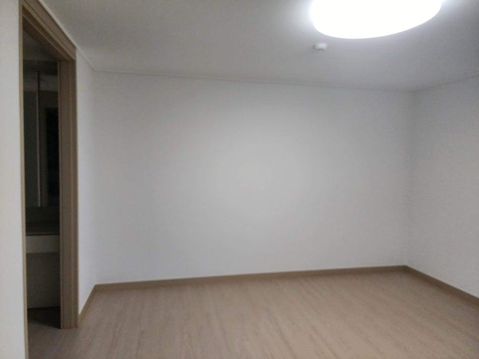흰 벽과 목재 바닥이 조화를 이루는 방