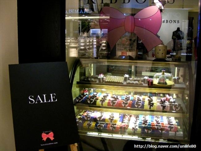 쇼핑몰 통로에 설치된 쇼케이스와 SALE 표지판