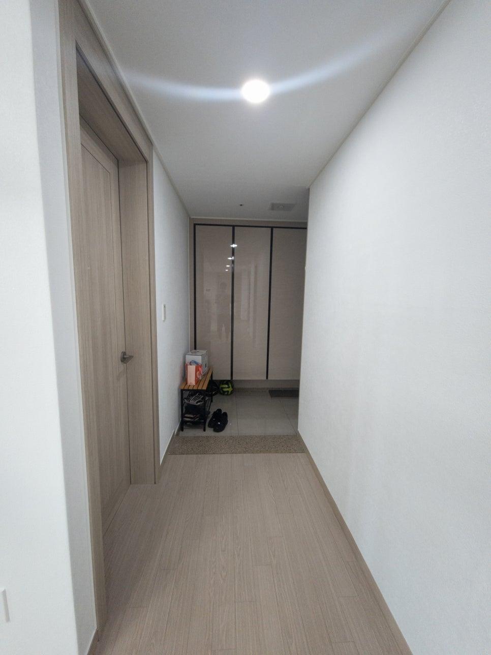 목재 바닥과 흰 벽이 어우러진 복도의 마무리 단계