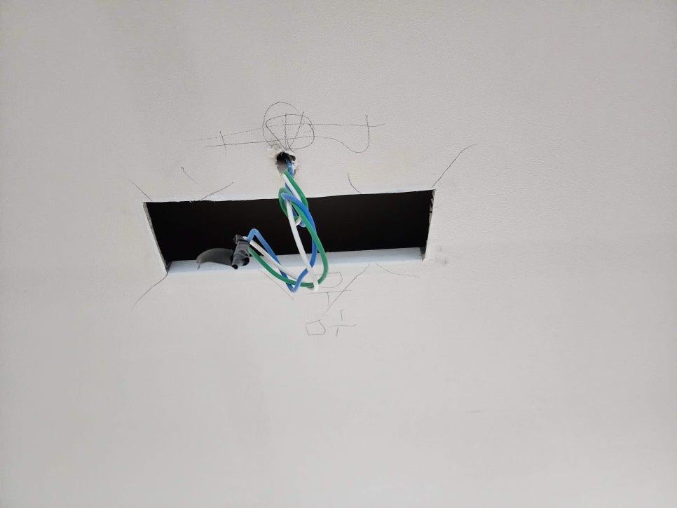 벽면 구멍 사이로 보이는 알록달록한 전선들