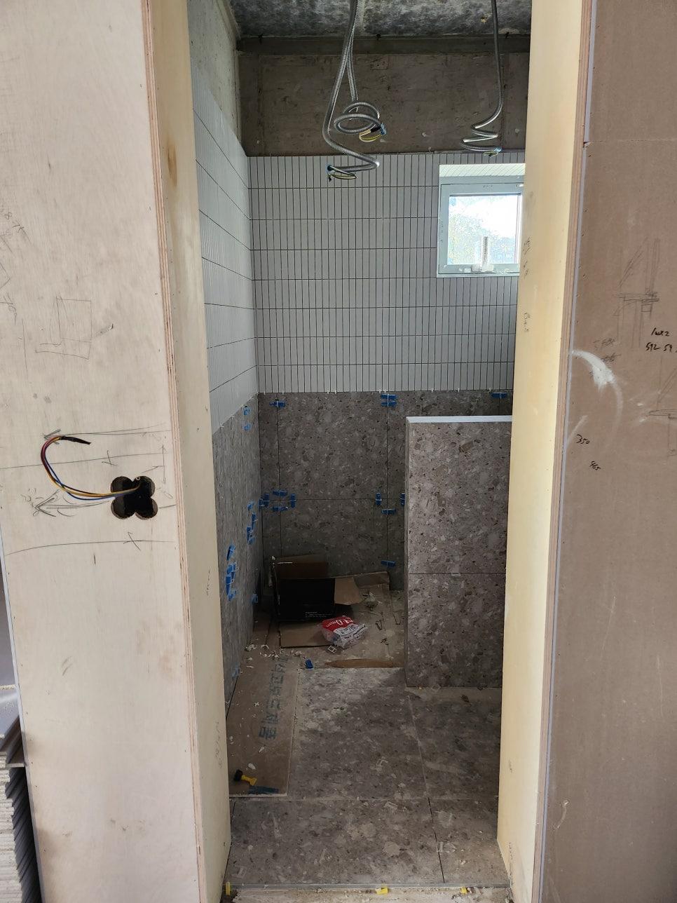 천장 전선이 노출된 상태의 타일 및 석재 기초 작업