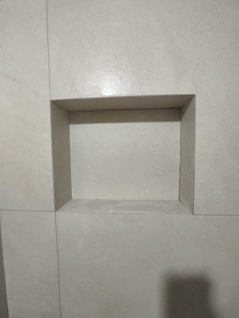 흰색 타일 벽에 내장된 직사각형 구멍
