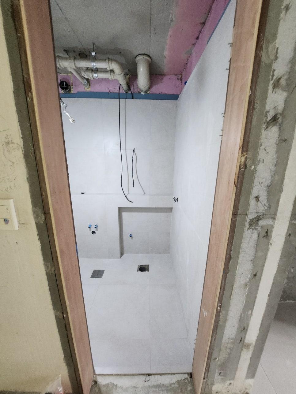 천장 배관이 노출된 상태의 타일 기초 작업
