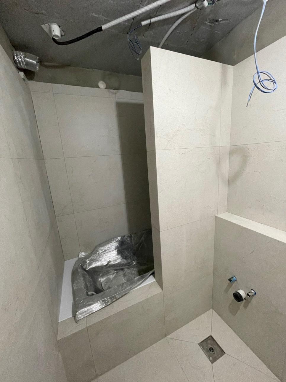 배관과 전선이 노출된 초기 공사 상태의 욕실