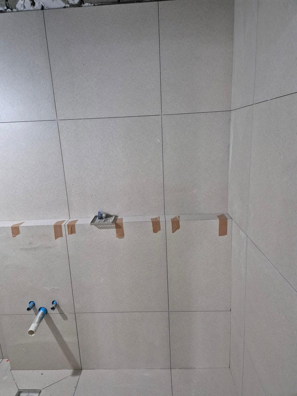 수전 부품과 파이프가 고정된 벽면