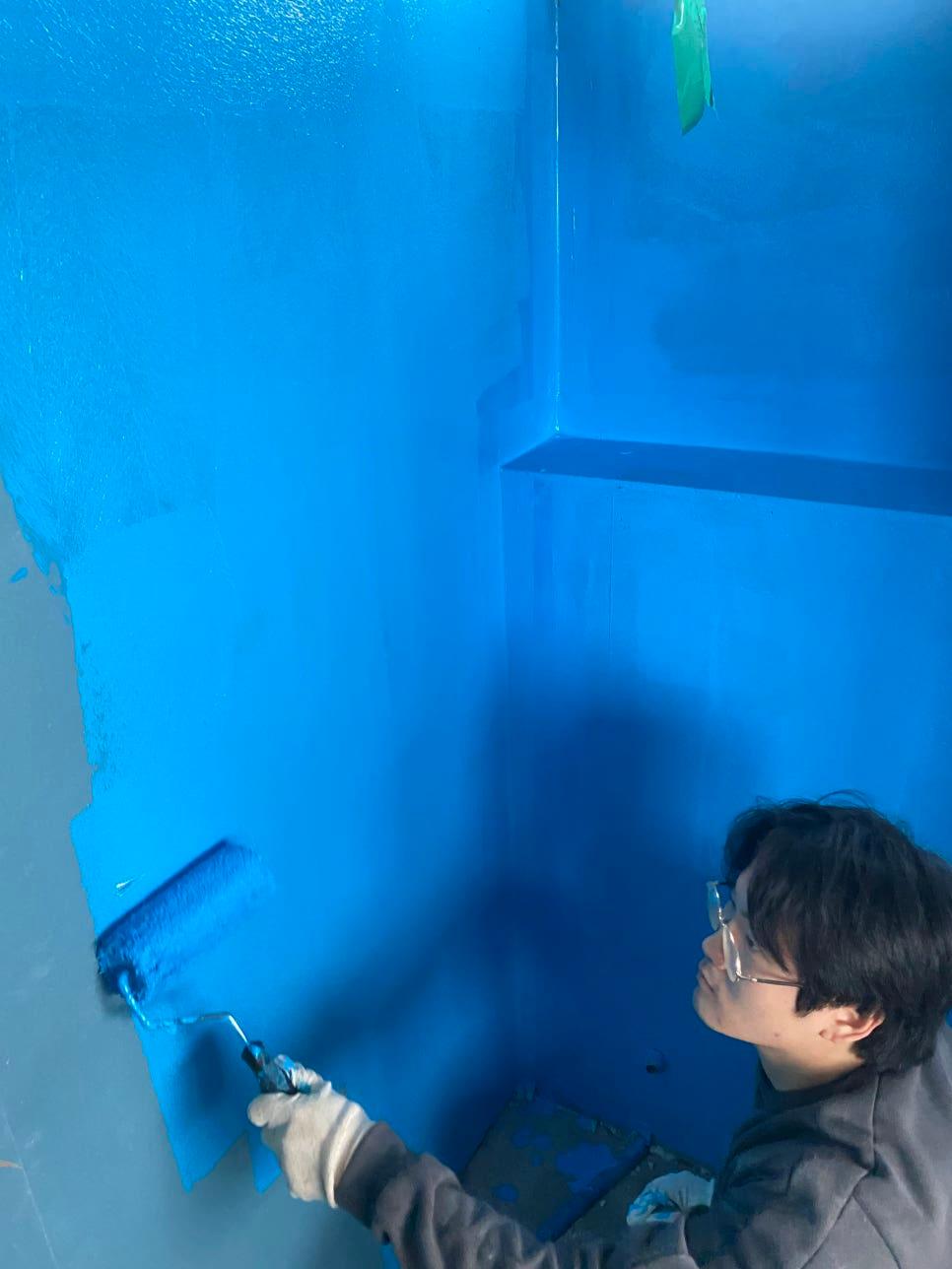벽면에 파란색 방수제를 도포하는 작업 과정