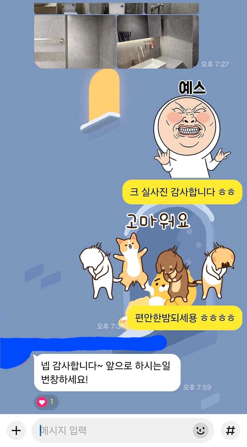 회색 타일 벽면과 화이트 세면대가 설치된 마무리 단계의 욕실