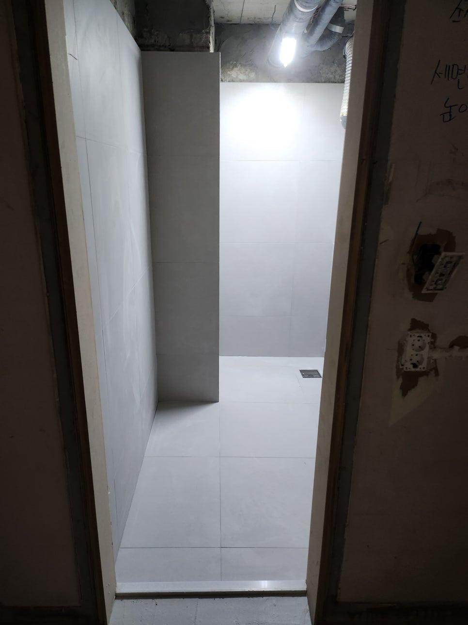 천장 배관과 조명이 보이는 타일 공간
