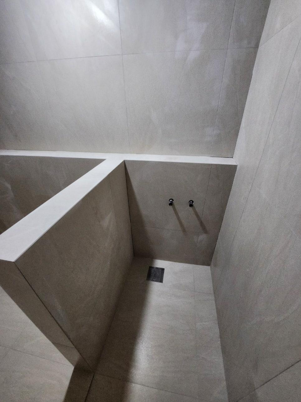 벽면 중앙에 검은색 수도꼭지가 설치된 상태