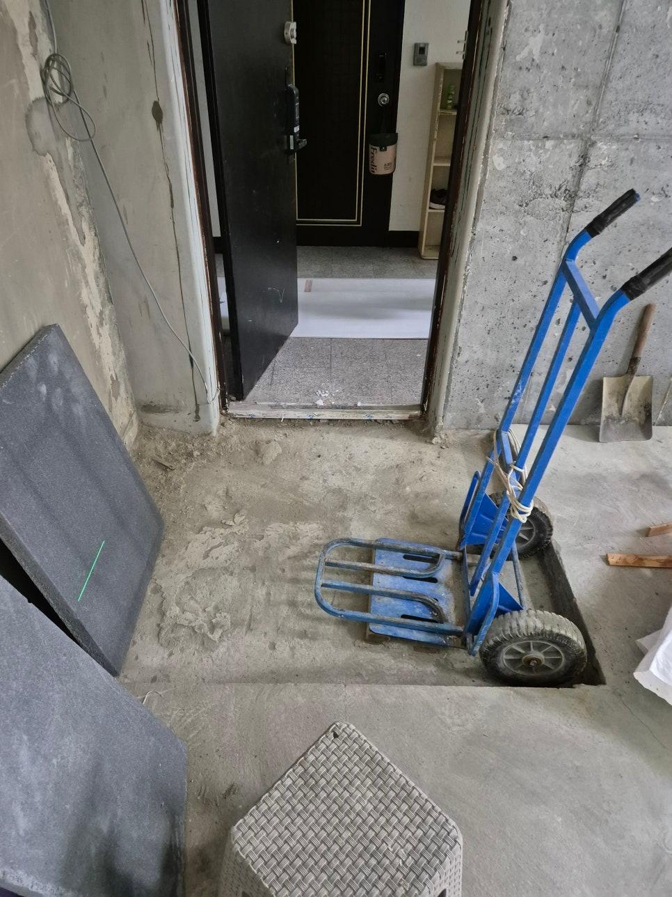 파란색 손수레가 놓인 콘크리트 벽과 바닥