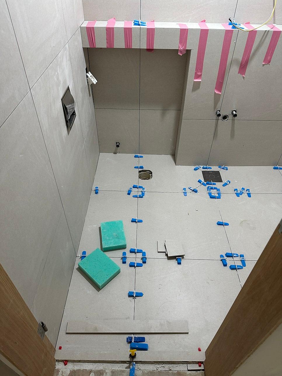 벽과 바닥 타일 시공 후 상단 고정 장치가 보이는 모습