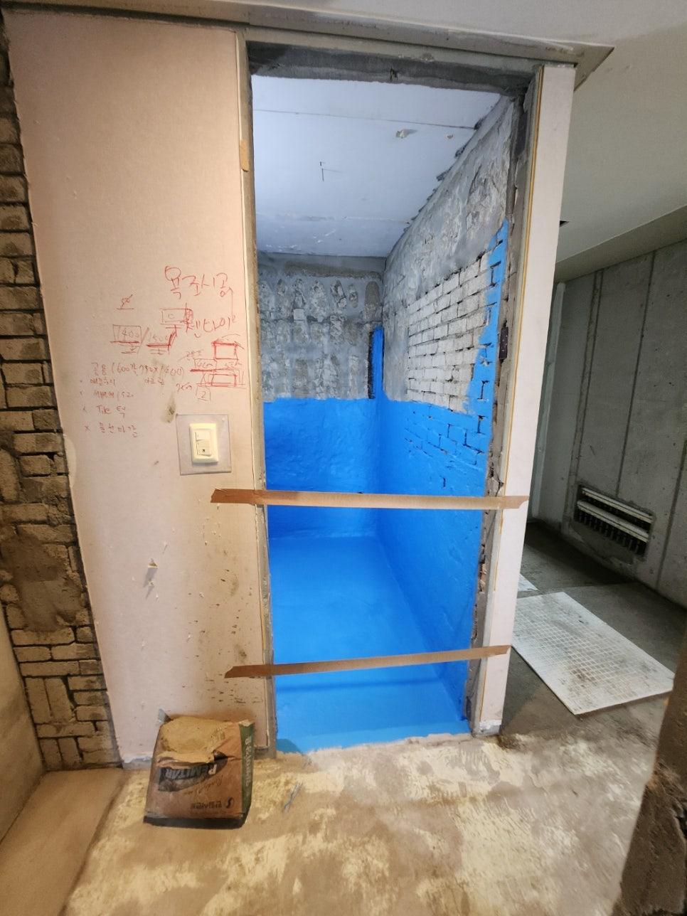 벽면이 철거되어 파란색 페인트와 문틀이 노출된 상태