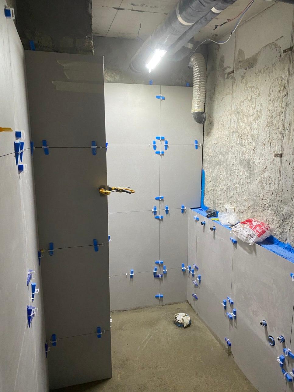 파란색 클립으로 고정된 벽면과 콘크리트 바닥