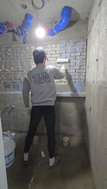 벽돌 벽에 타일을 붙이고 있는 공사 과정
