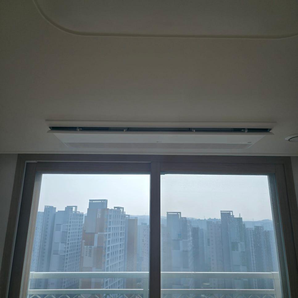 천장 공기 조절 장치와 고층 아파트 배경의 창문