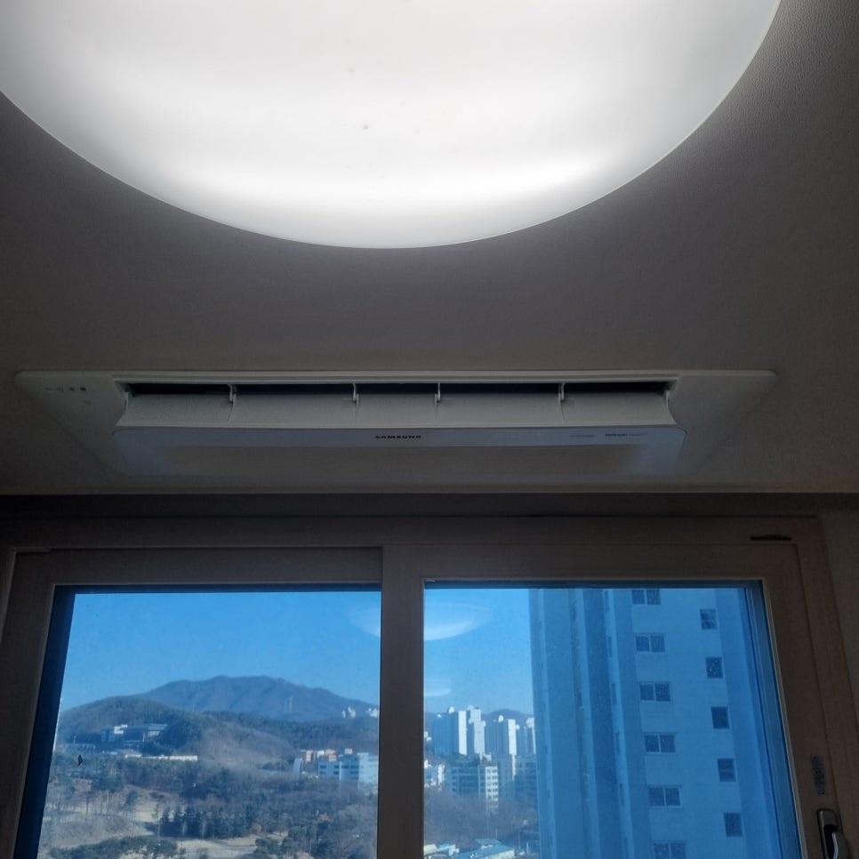 원형 조명과 냉장고가 있는 공간의 천장형 에어컨