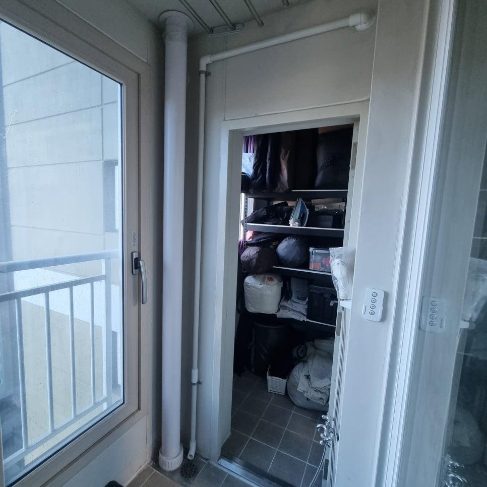 흰색 파이프와 수납장이 보이는 현관