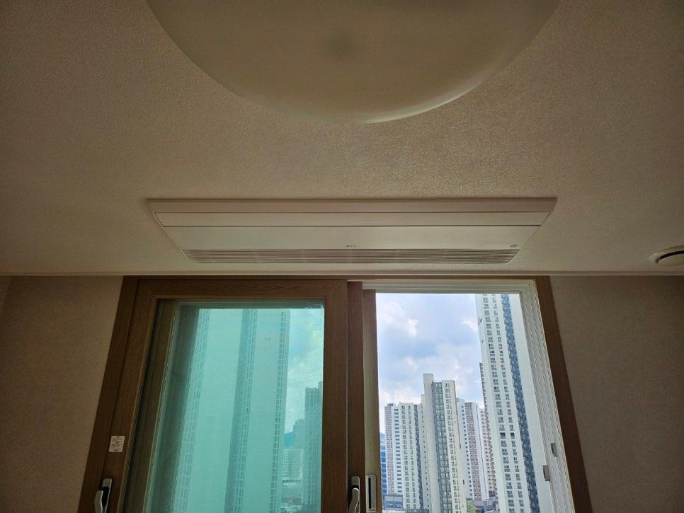 천장 공기순환기와 창밖 고층 건물 전경
