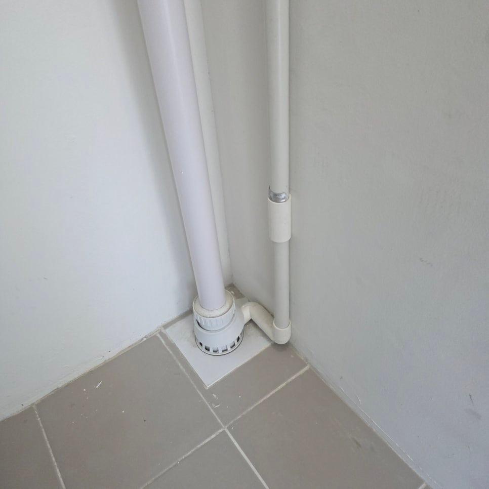 구석 공간에 설치된 흰색 PVC 배관