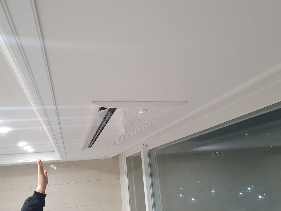 천장 에어컨과 벽면 타일이 보이는 실내