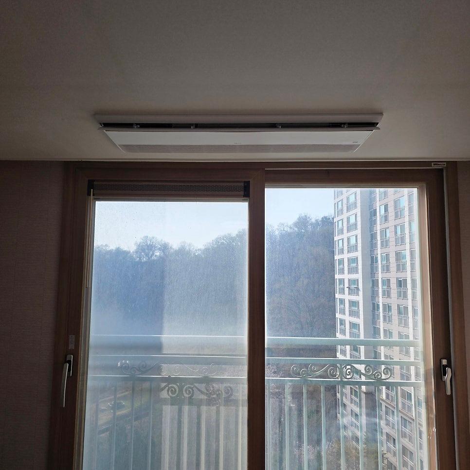 창문 위에 설치된 기존 에어컨과 발코니 난간