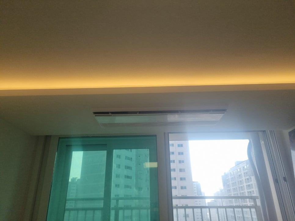 창문 근처 천장에 설치된 에어컨과 외부 전경