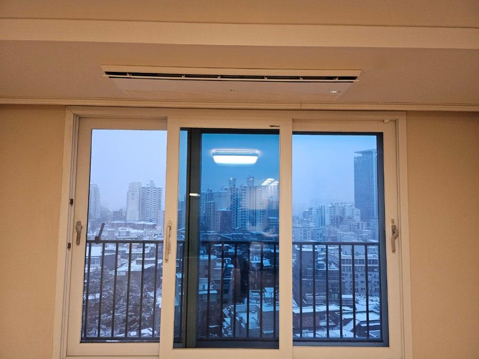 베이지색 천장 마감과 흰색 슬라이딩 창이 보이는 공간