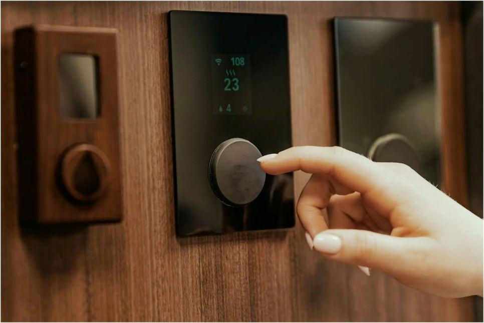 나무 장식판 위에 설치된 블랙 스마트 온도 조절기