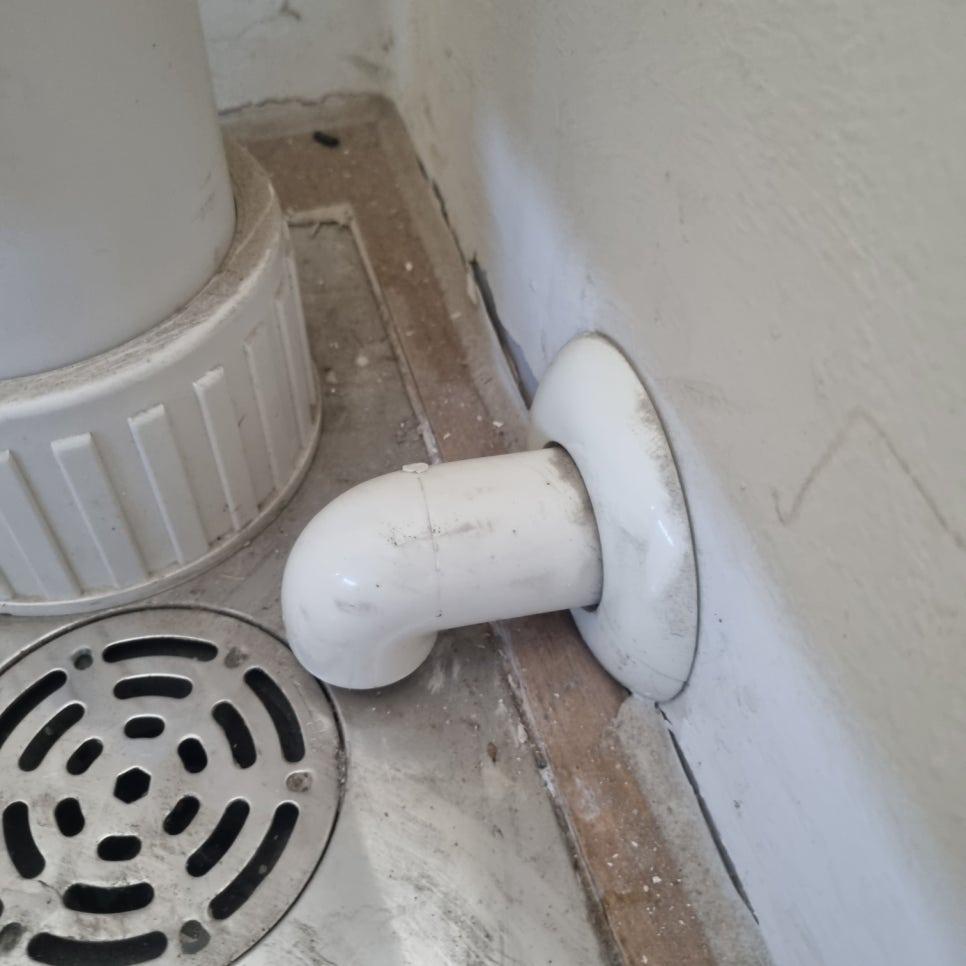 흰색 PVC 배관과 금속 배수판의 연결 상태