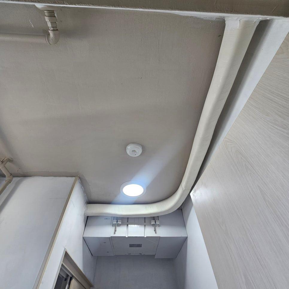 화재 경보기와 조명 사이의 흰색 배관