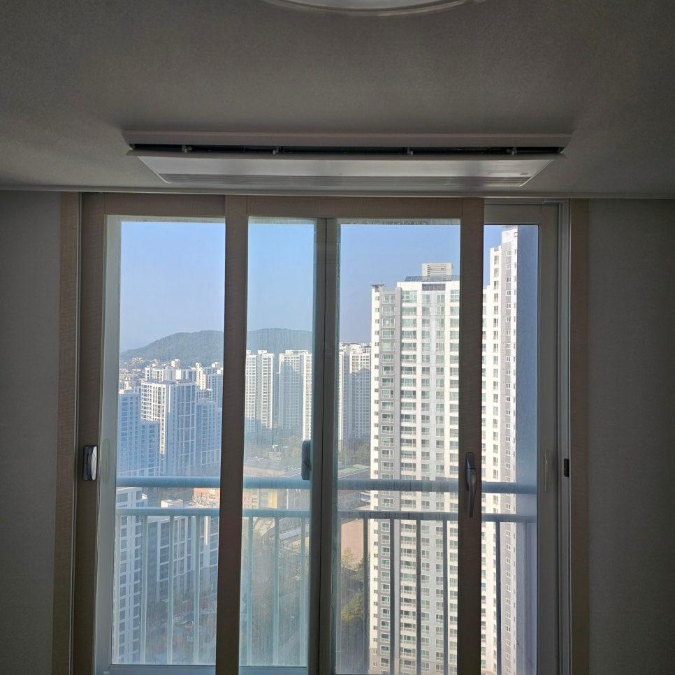 외부 고층 건물과 산이 배경인 창문 근접 샷