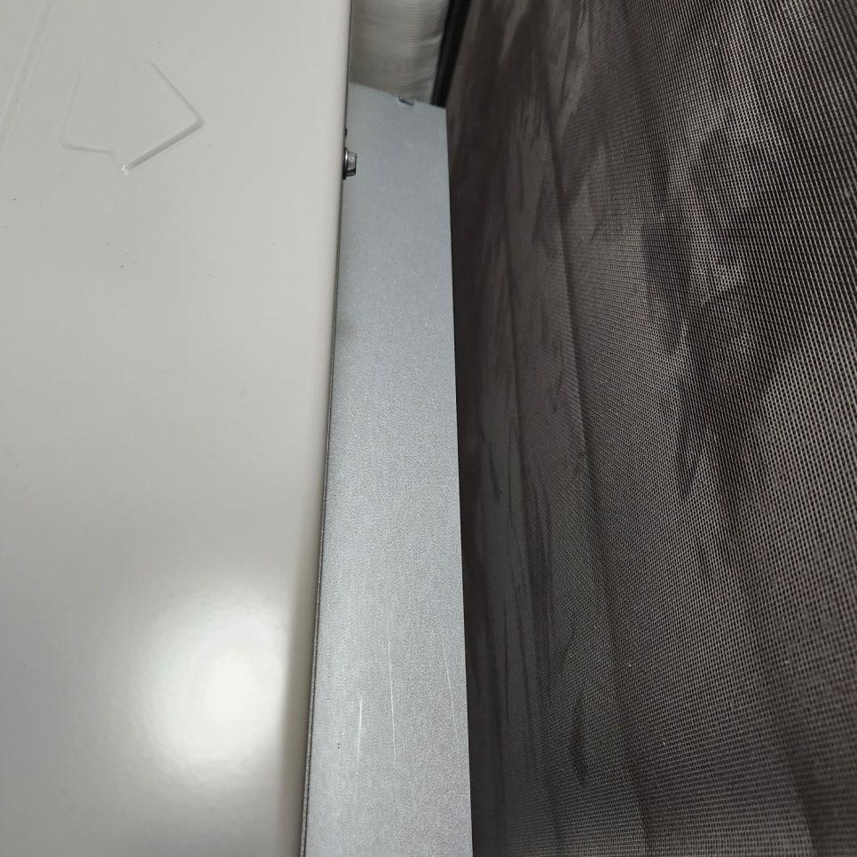 흰색 벽과 회색 슬라이딩도어 사이의 좁은 공간