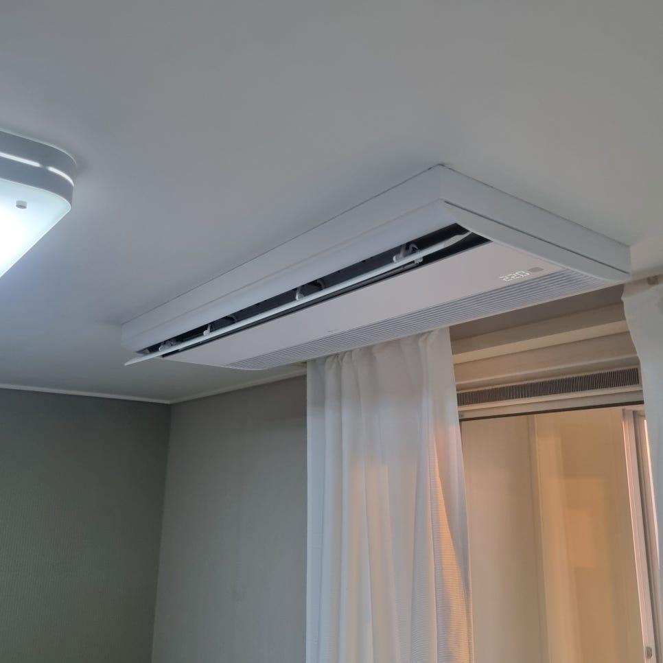 흰색 커튼과 조명이 어우러진 천장 기기