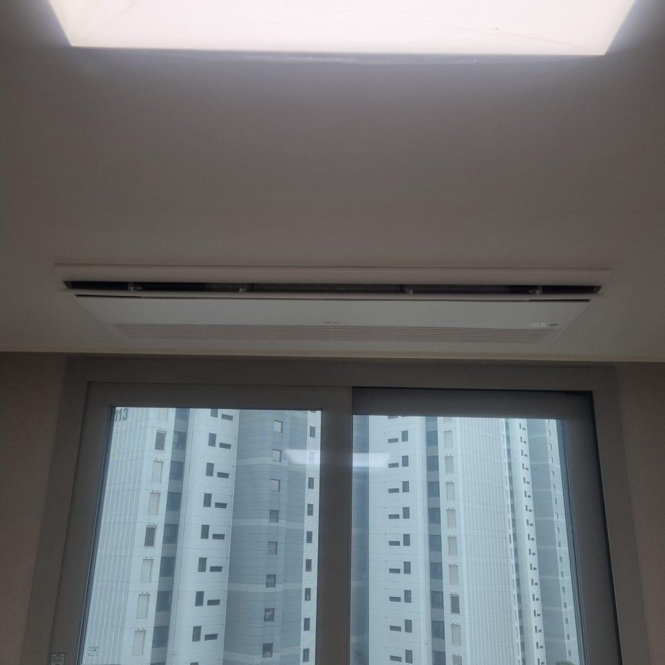 천장 에어컨 설치 모습과 외부 고층 건물 뷰