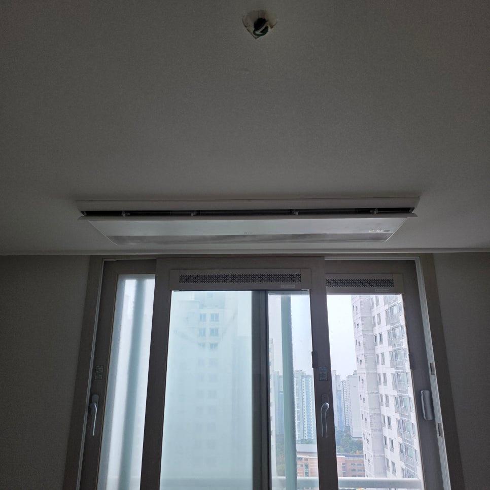 외부 건물이 보이는 슬라이딩 유리문과 천장 공기순환기
