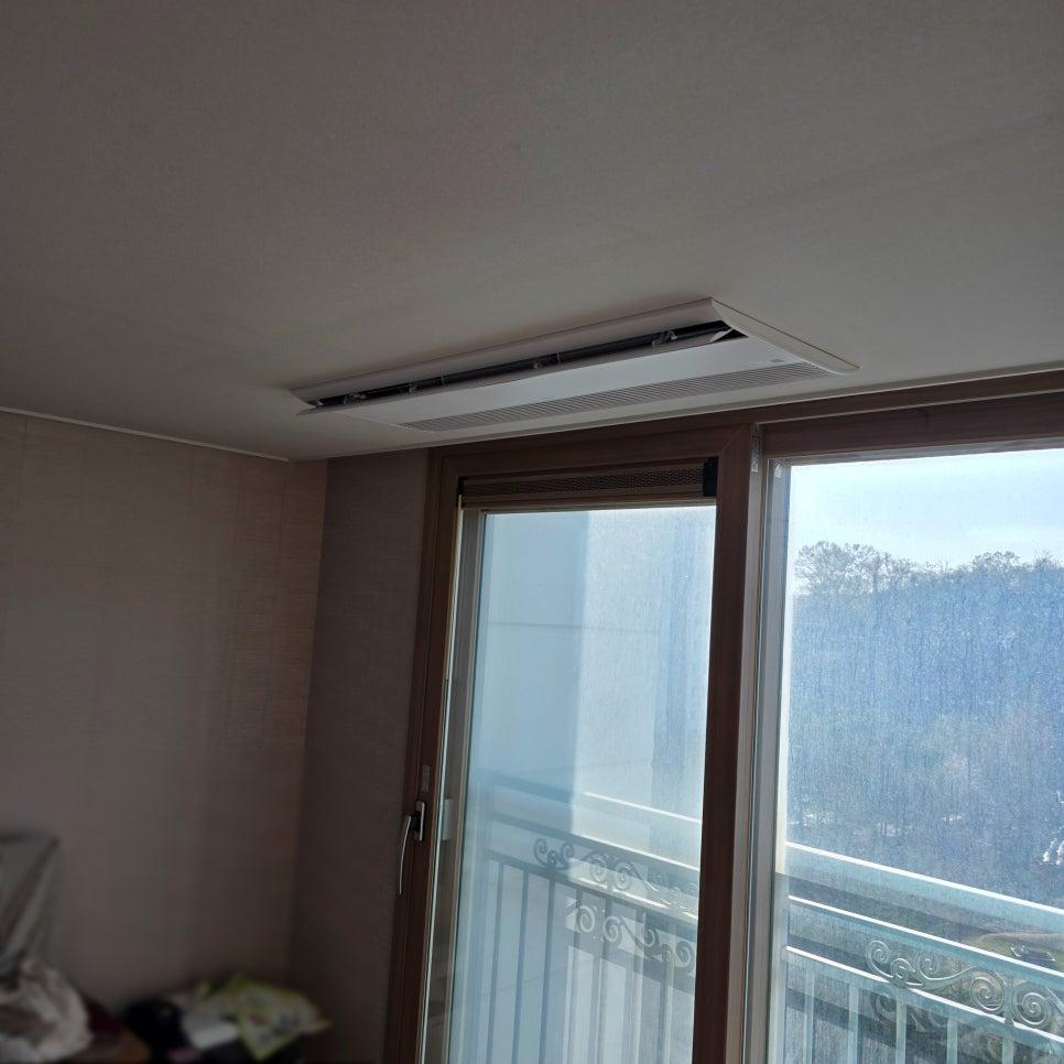 천장 공기 순환기와 베이지색 벽지가 보이는 창호 근접 샷
