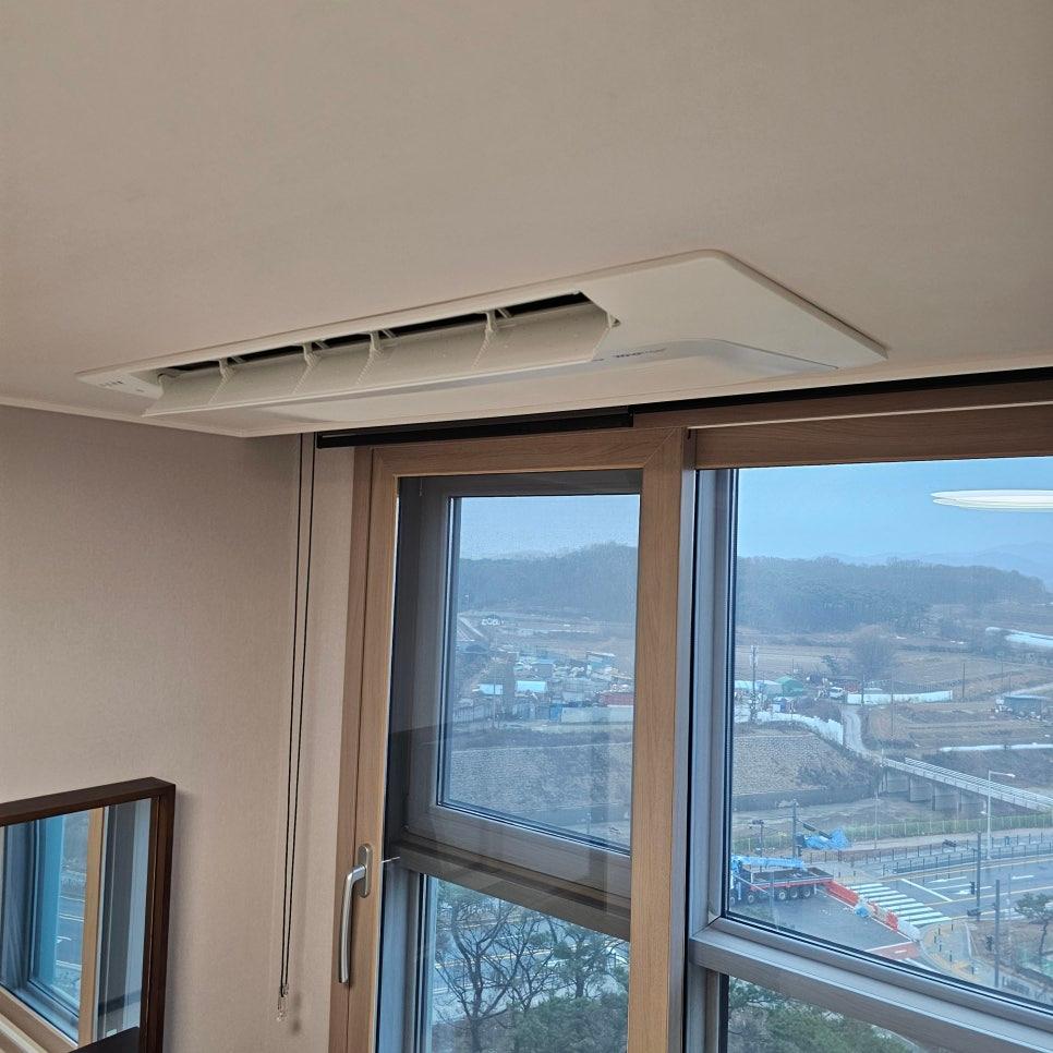 흰색 천장에 설치된 공기순환기와 나무 테두리의 창호