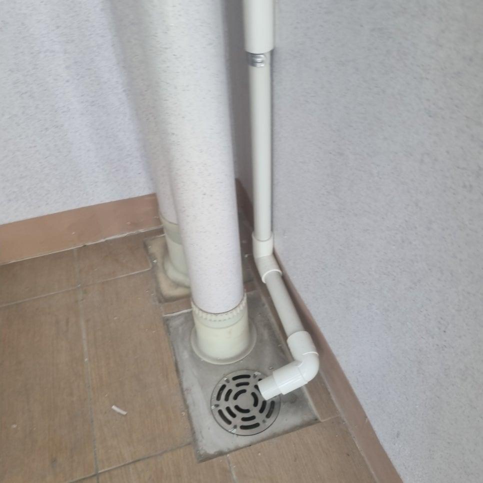 벽과 바닥 접합부의 흰색 PVC관과 배수구