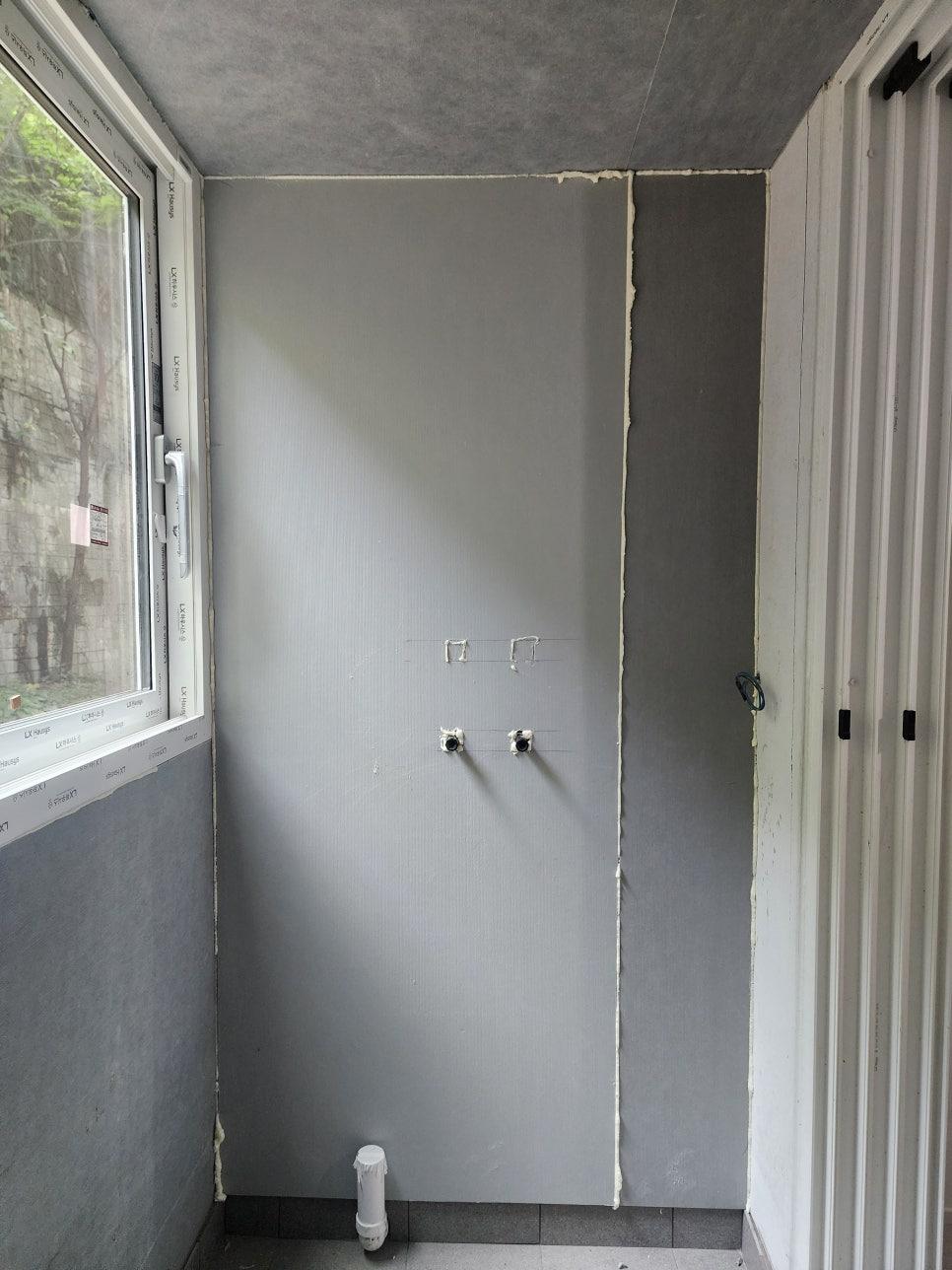 창호와 문이 설치된 회색 벽면의 시공 전 상태