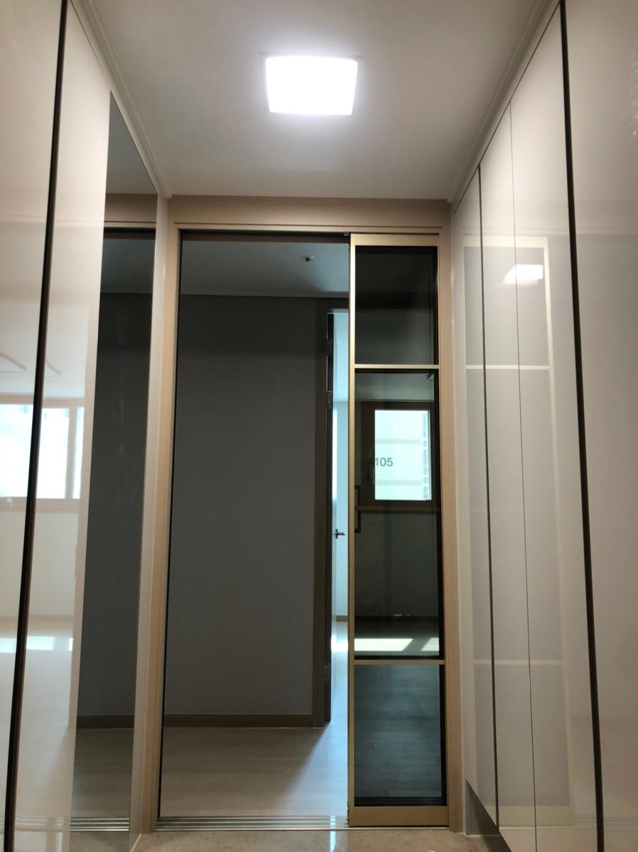 화이트 벽면과 투명 도어가 만드는 정갈한 복도