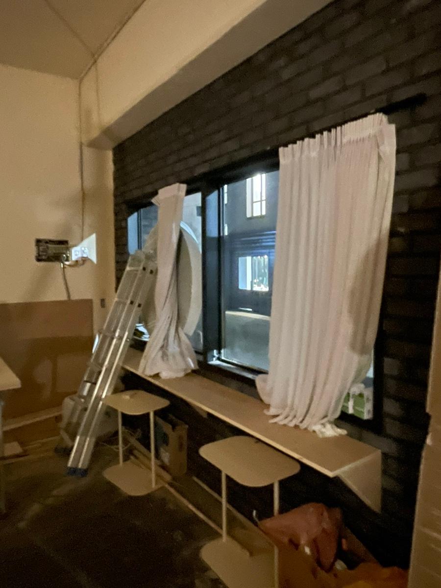 벽돌 벽과 흰색 커튼이 있는 철거 중인 공간