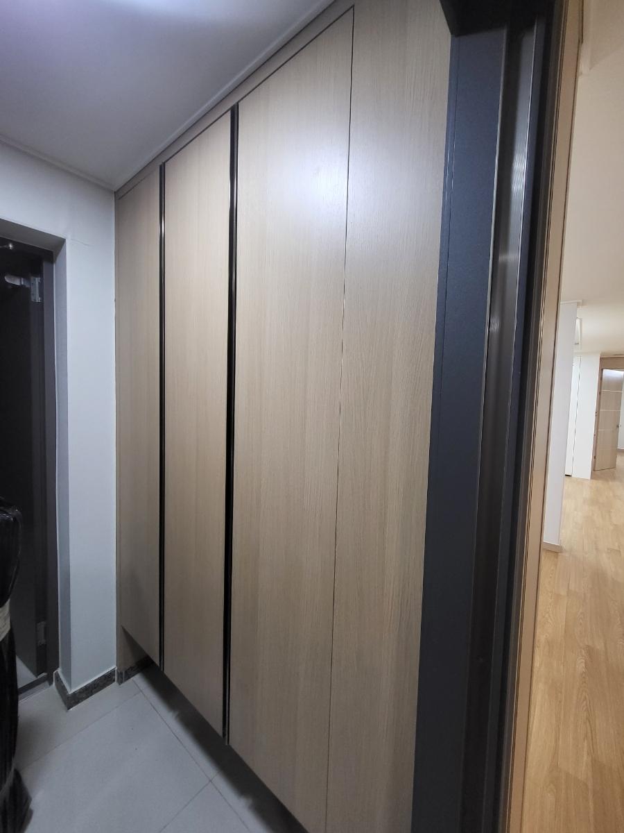 회색 벽면과 블랙 프레임 도어가 매치된 복도