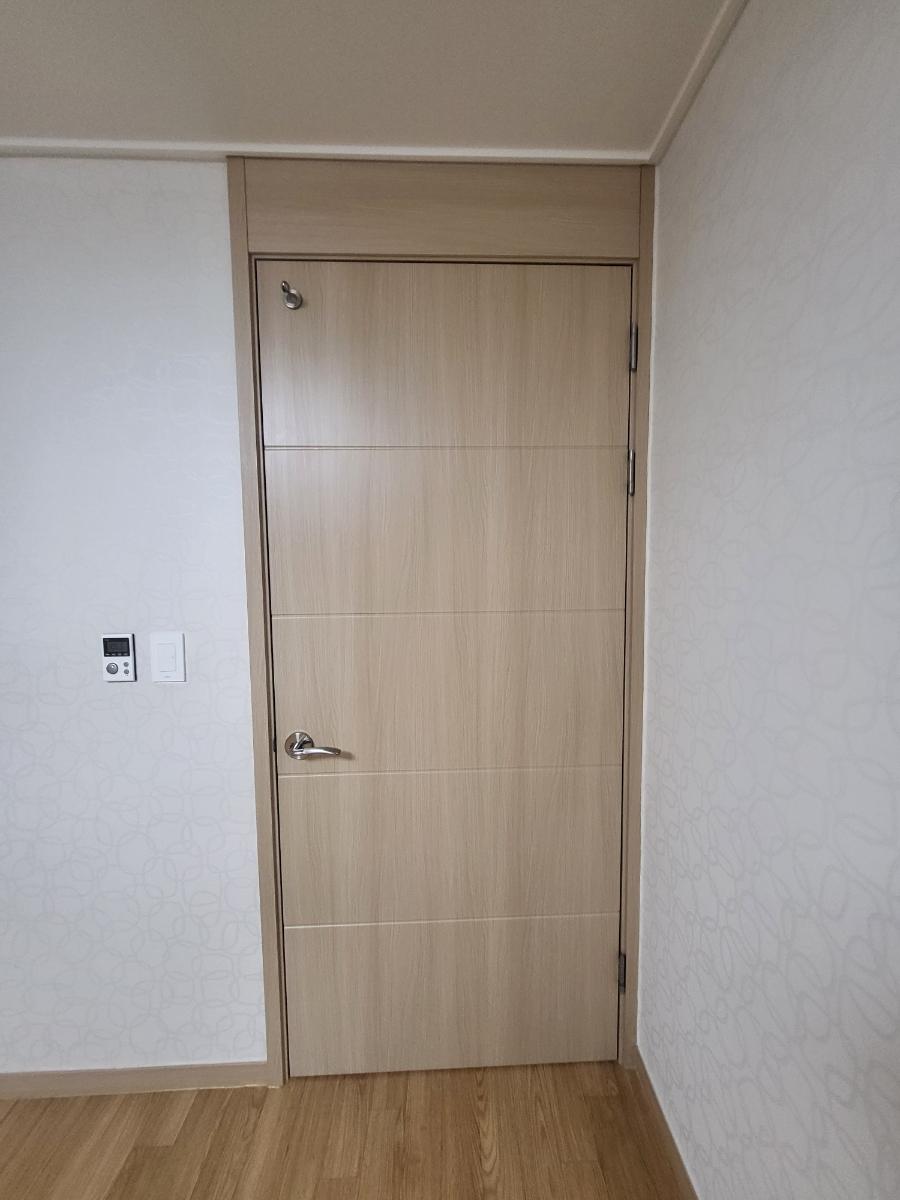 베이지색 목재 패널 도어와 벽지의 부드러운 조화