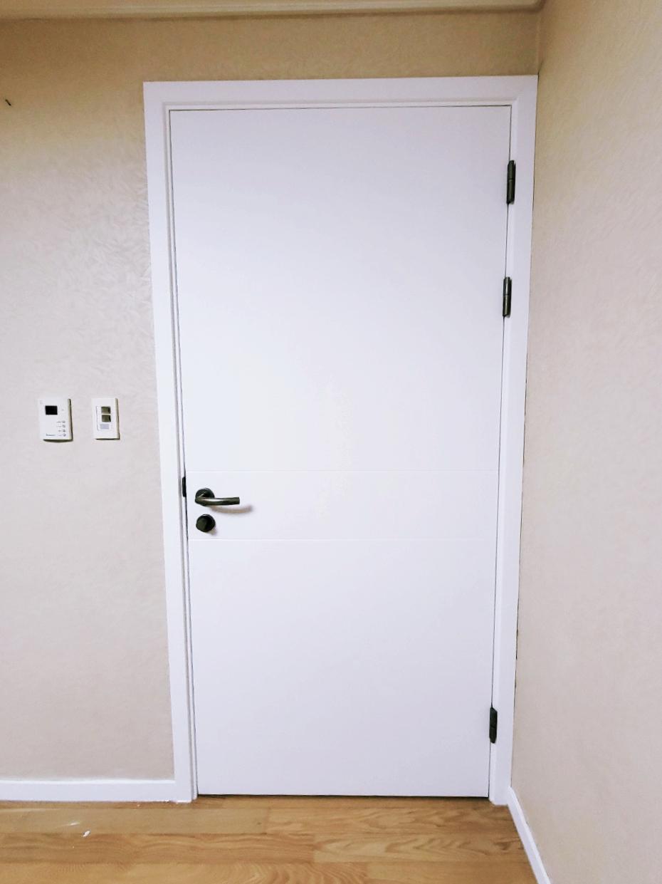 흰색 도어와 벽지, 목재 바닥재가 있는 현관