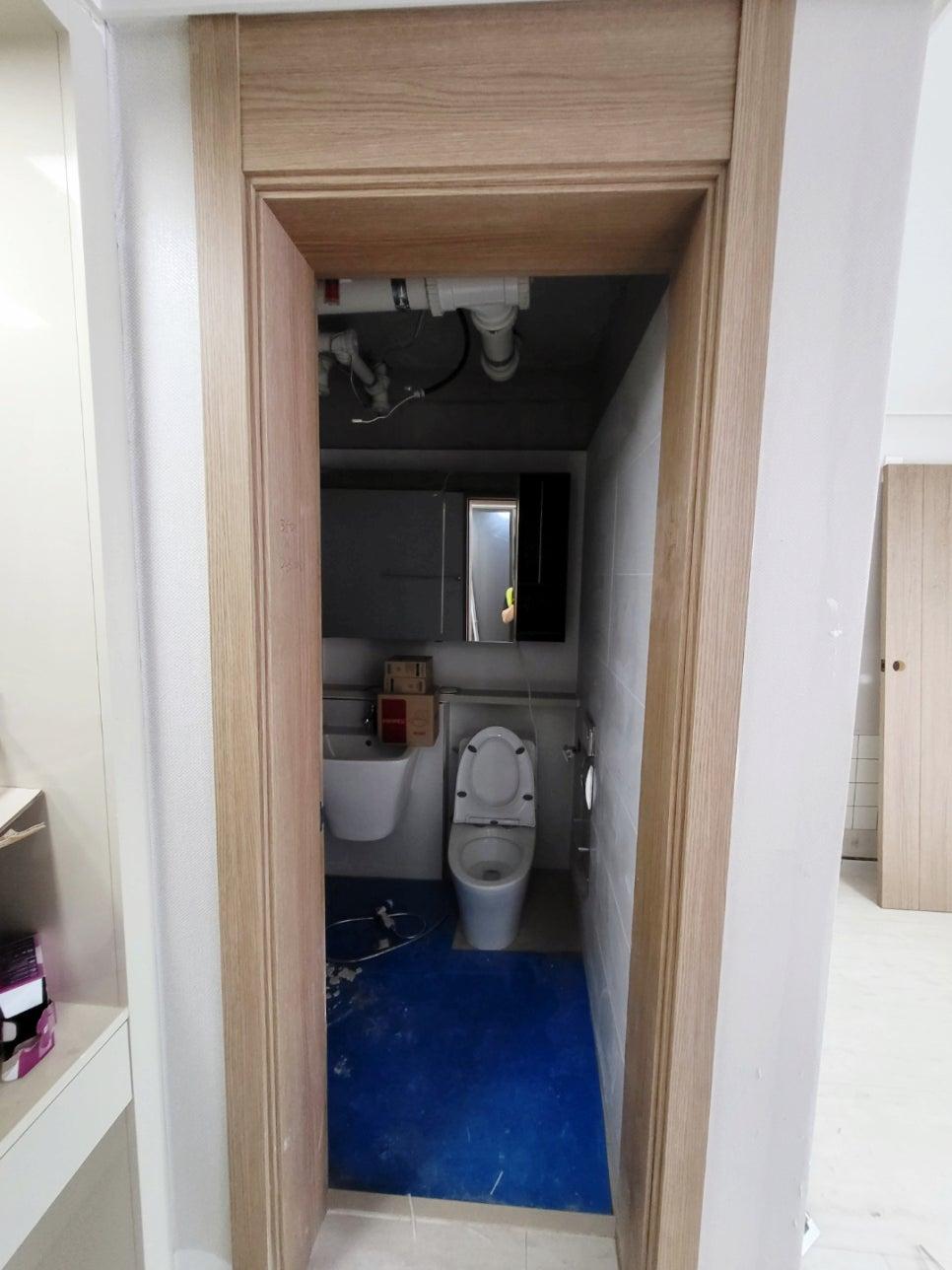 파란 보호재가 깔린 공사 중인 욕실 내부