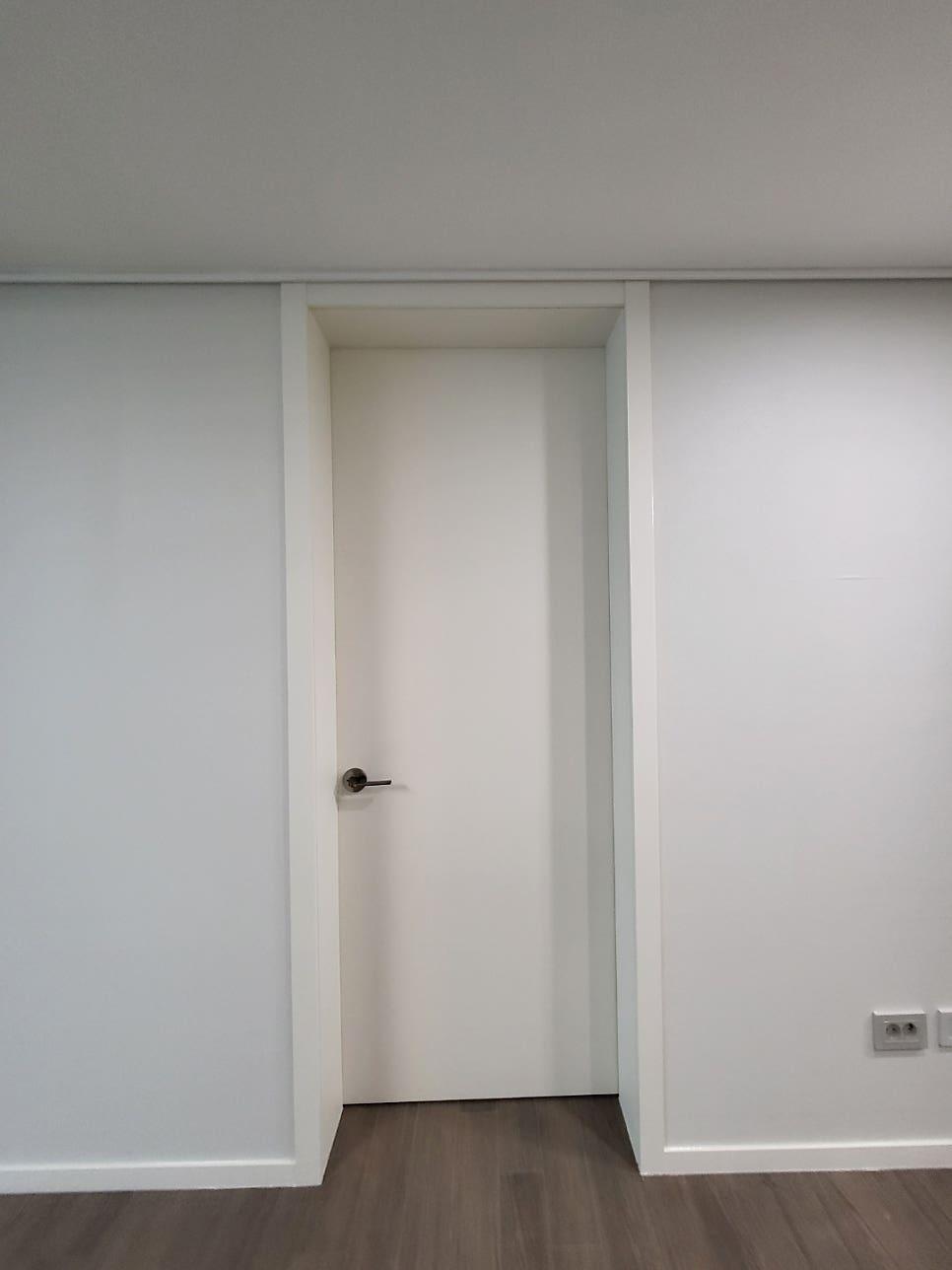 흰 벽과 문, 갈색 마루가 조화를 이루는 근접 모습