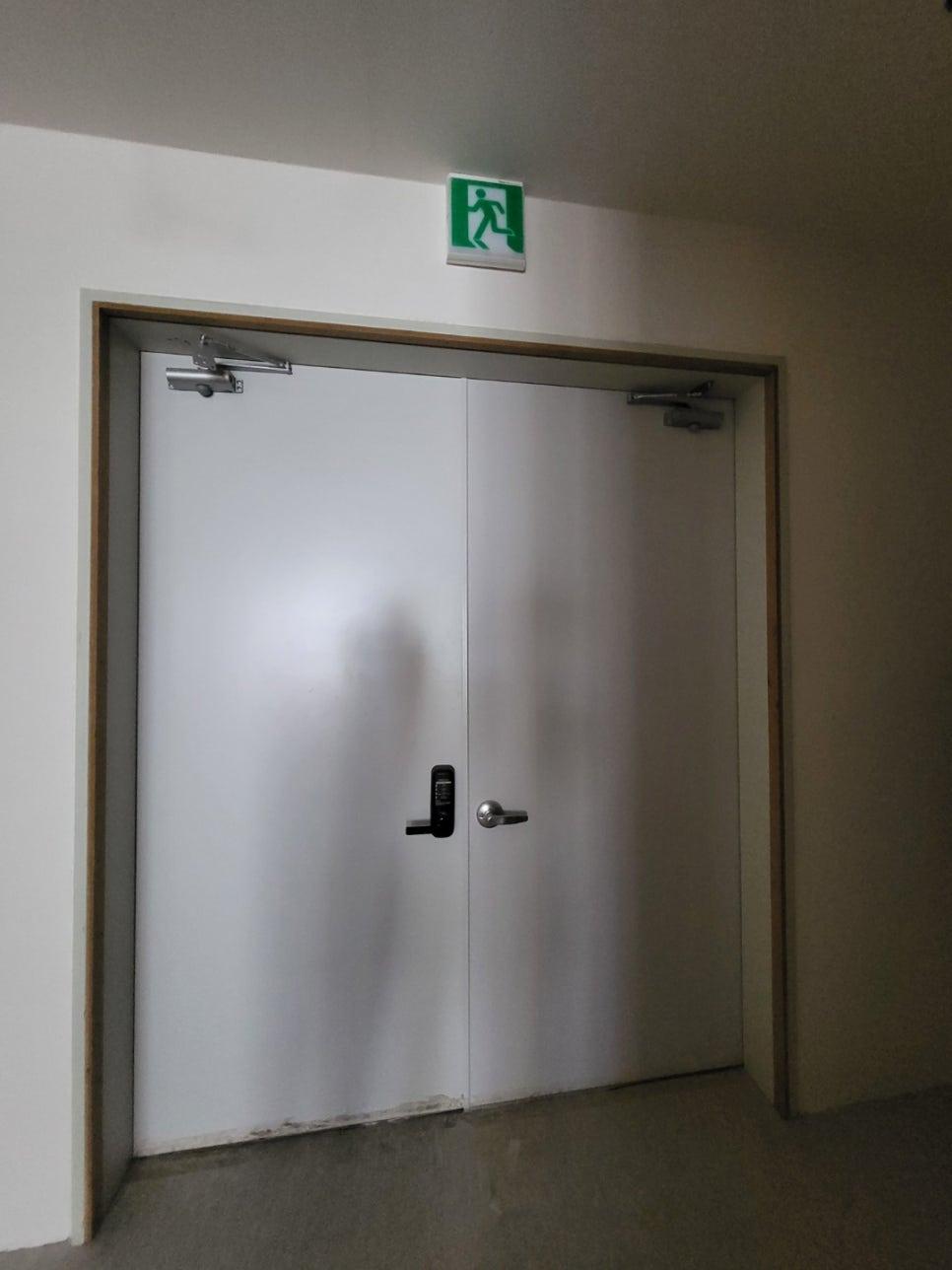 깔끔한 화이트 도어와 녹색 안내판의 조화