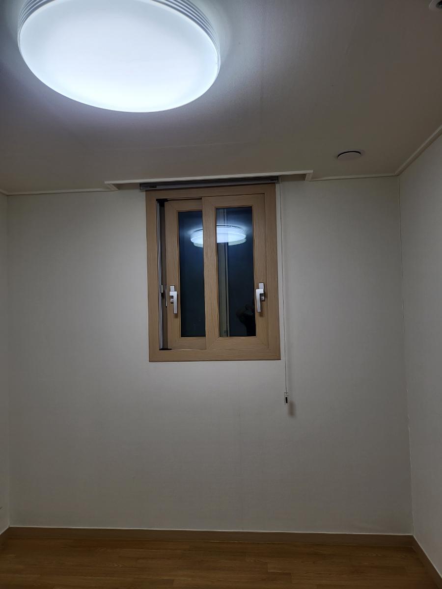 나무 톤 창호와 원형 조명이 어우러진 방 내부