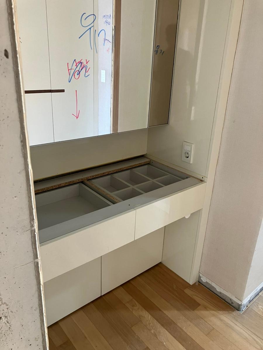 흰색 수납장과 거울이 있는 화장실 마감 작업 모습
