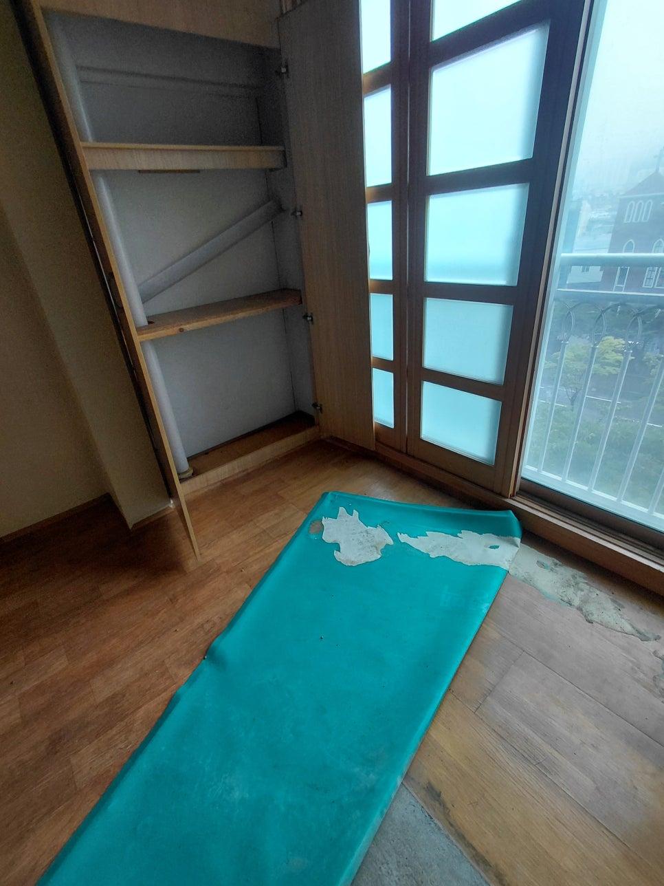 파란 매트와 목재 바닥이 깔린 방 안 모습